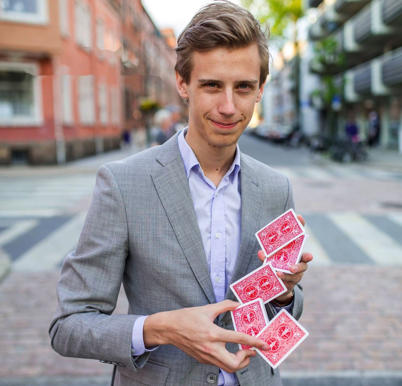 Tryllekunstner Fredrik Moe med spillkort i en bygate i Kristiansand